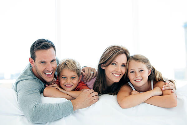 family-on-couch-smiling-white-background